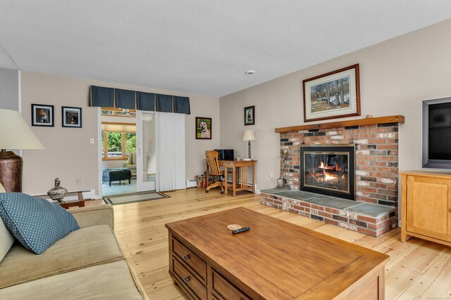 35 Whitethorn Dr, Guilford, CT 06437 - living area with light wood-style floors, a brick fireplace, and baseboard heating