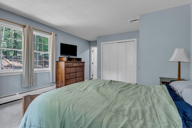 35 Whitethorn Dr, Guilford, CT 06437 - bedroom featuring baseboard heating, a textured ceiling, a closet, and carpet