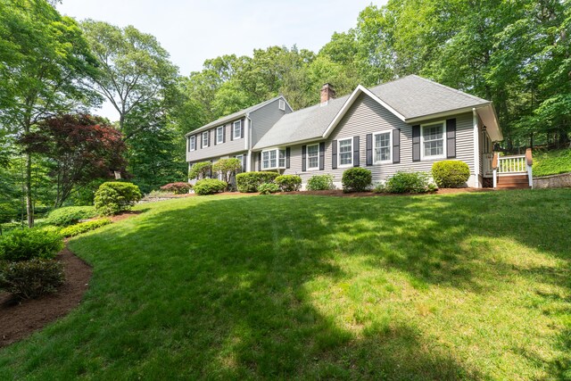 35 Whitethorn Dr, Guilford, CT 06437 - view of front of home featuring a chimney, a front lawn, roof with shingles, and view of wooded area