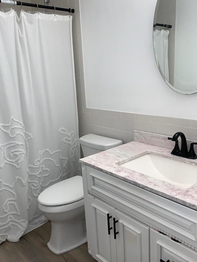 92 Jones Dr, New Britain, CT 06053 - full bathroom with tile walls, vanity, wood finished floors, toilet, and curtained shower