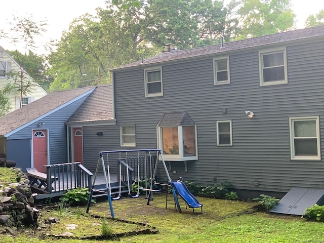 92 Jones Dr, New Britain, CT 06053 - back of house featuring a wooden deck, a playground, a shingled roof, and a lawn