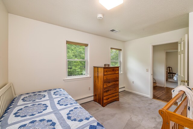 47 Davis Rd, Mansfield, CT 06268 - bedroom with a baseboard radiator, light colored carpet, and a textured ceiling