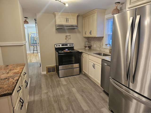 262 Meyer Rd, Torrington, CT 06790 - kitchen with stainless steel appliances, under cabinet range hood, light wood-style floors, backsplash, and dark stone counters