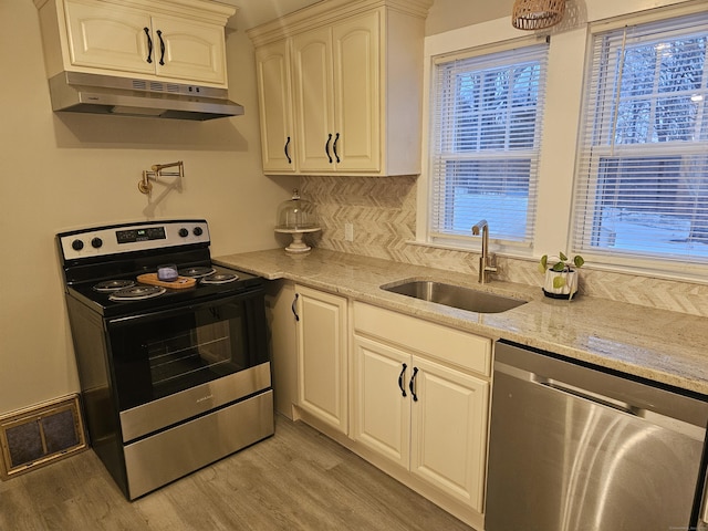 262 Meyer Rd, Torrington, CT 06790 - kitchen featuring stainless steel appliances, under cabinet range hood, light wood finished floors, and light stone countertops