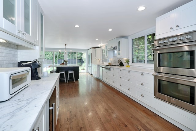 29 Bayberry Rd, Fairfield, CT 06825 - kitchen with stainless steel appliances, decorative backsplash, white cabinetry, glass insert cabinets, and dark wood-type flooring