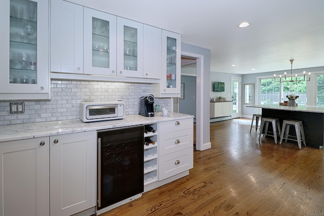 29 Bayberry Rd, Fairfield, CT 06825 - kitchen with wine cooler, backsplash, white cabinets, a chandelier, and a kitchen bar