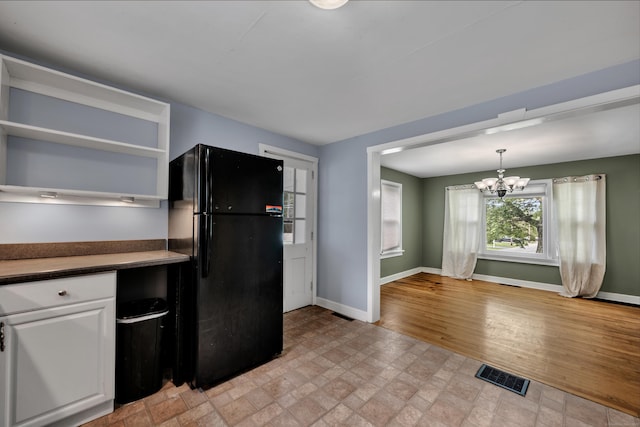 824 Torringford W St, Torrington, CT 06790 - kitchen featuring freestanding refrigerator, dark countertops, a chandelier, white cabinetry, and open shelves