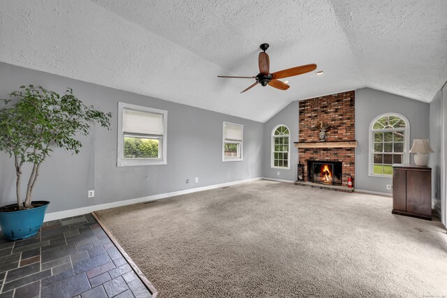 824 Torringford W St, Torrington, CT 06790 - unfurnished living room featuring a textured ceiling, lofted ceiling, a ceiling fan, plenty of natural light, and a brick fireplace
