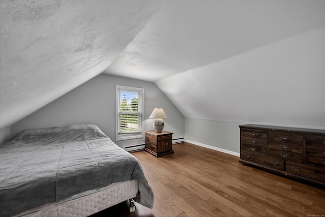 824 Torringford W St, Torrington, CT 06790 - bedroom with wood finished floors, vaulted ceiling, a baseboard heating unit, and a baseboard radiator