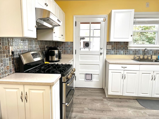 17 Rock Spring Rd, Stamford, CT 06906 - kitchen featuring range with two ovens, under cabinet range hood, white cabinets, backsplash, and light countertops