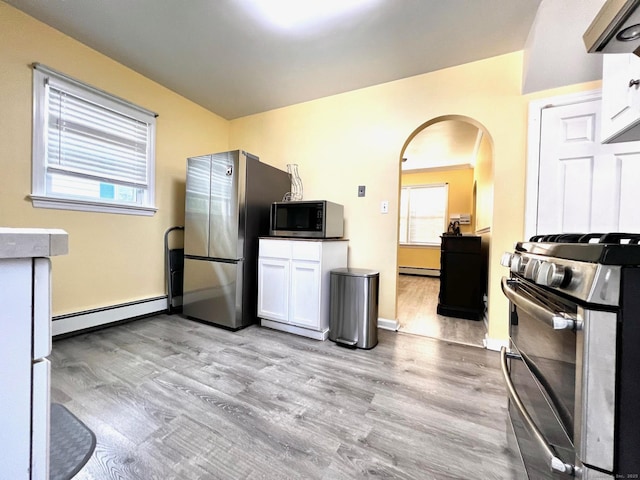 17 Rock Spring Rd, Stamford, CT 06906 - kitchen with appliances with stainless steel finishes, a baseboard heating unit, light wood-type flooring, arched walkways, and a baseboard radiator