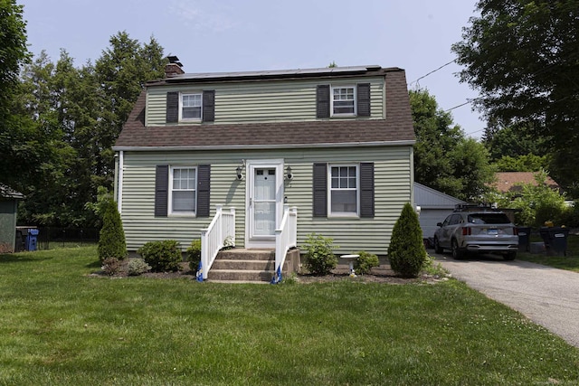12 John St, Killingly, CT 06239 - view of front facade featuring a shingled roof, a front yard, a chimney, and an outdoor structure