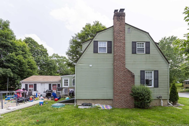 12 John St, Killingly, CT 06239 - rear view of house featuring a chimney, a lawn, and a gambrel roof