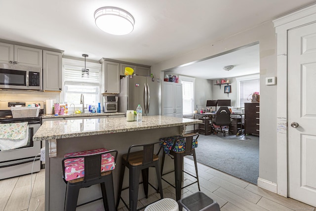 12 John St, Killingly, CT 06239 - kitchen featuring appliances with stainless steel finishes, a breakfast bar area, plenty of natural light, and open floor plan