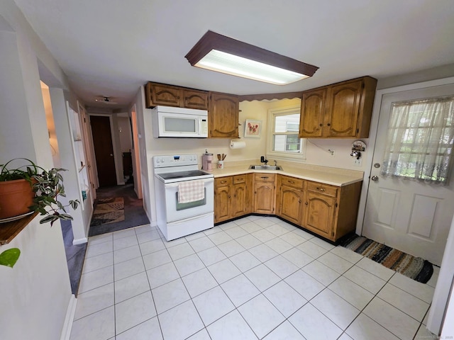 149 Branford St, Manchester, CT 06040 - kitchen with white appliances, light countertops, brown cabinetry, and a sink