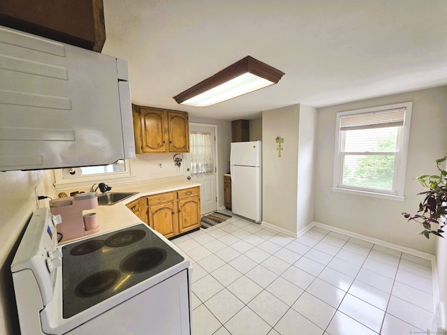 149 Branford St, Manchester, CT 06040 - kitchen with white appliances, a sink, brown cabinetry, and baseboards