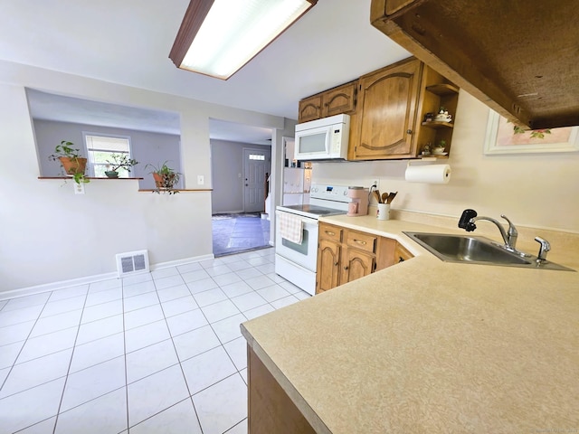149 Branford St, Manchester, CT 06040 - kitchen with white appliances, a sink, light countertops, light tile patterned flooring, and brown cabinetry