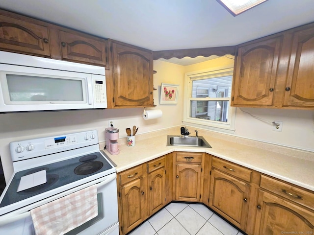 149 Branford St, Manchester, CT 06040 - kitchen with white appliances, a sink, light countertops, light tile patterned flooring, and brown cabinetry