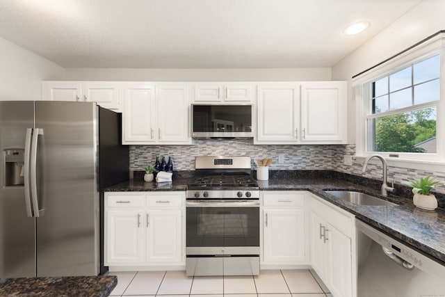 75 Brittania Rd Unit 75, Danbury, CT 06811 - kitchen with stainless steel appliances, a sink, white cabinetry, tasteful backsplash, and dark stone countertops