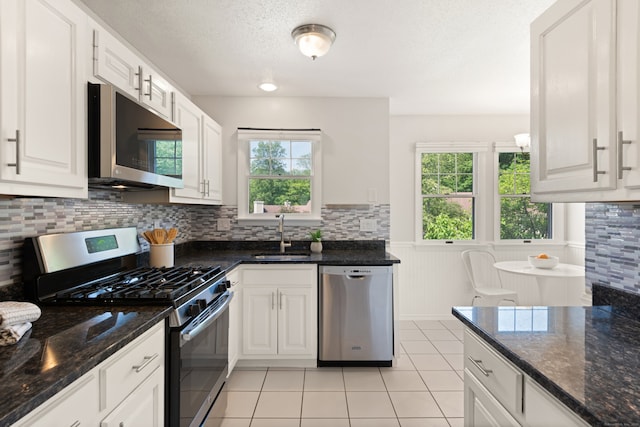 75 Brittania Rd Unit 75, Danbury, CT 06811 - kitchen with stainless steel appliances, a sink, healthy amount of natural light, a wainscoted wall, and light tile patterned flooring
