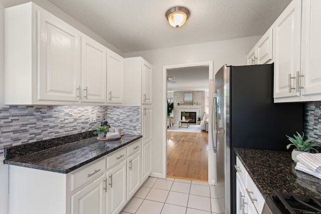 75 Brittania Rd Unit 75, Danbury, CT 06811 - kitchen featuring white cabinetry, light tile patterned floors, tasteful backsplash, and a textured ceiling