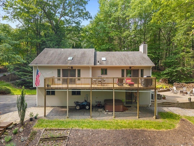 2 Round Hill Rd, Shelton, CT 06484 - rear view of property featuring a hot tub, a patio area, a deck, a chimney, and a shingled roof