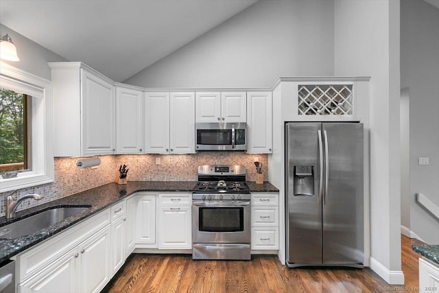 2 Round Hill Rd, Shelton, CT 06484 - kitchen with appliances with stainless steel finishes, white cabinets, decorative backsplash, dark stone counters, and high vaulted ceiling