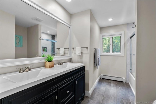 2 Round Hill Rd, Shelton, CT 06484 - bathroom featuring baseboard heating, wood finished floors, double vanity, and enclosed tub / shower combo