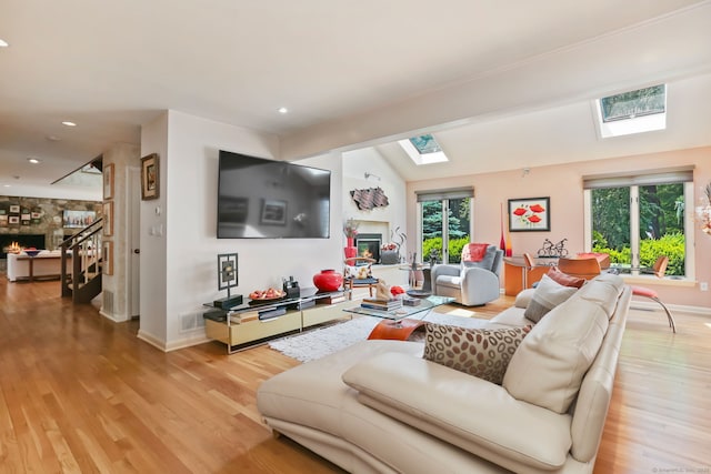 8 Hedgerow Cmn, Weston, CT 06883 - living area with a skylight, a warm lit fireplace, light wood-style floors, lofted ceiling, and baseboards