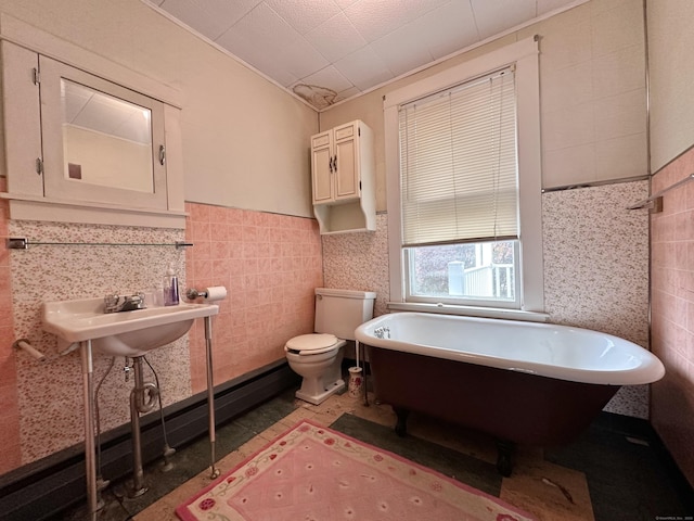 189 N Main St, Griswold, CT 06351 - bathroom featuring a freestanding bath, tile walls, toilet, a wainscoted wall, and a sink
