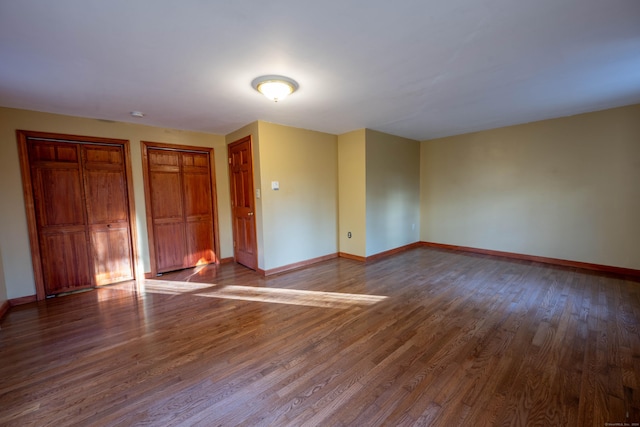65 Spring St, Middlefield, CT 06481 - unfurnished bedroom featuring wood finished floors, baseboards, and two closets