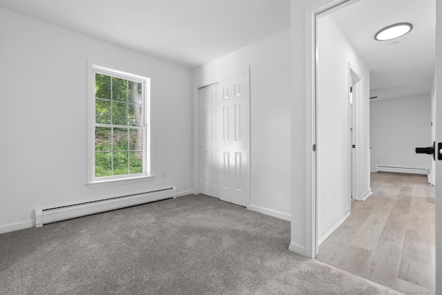59 Colony St, Bristol, CT 06010 - unfurnished bedroom featuring baseboard heating, a baseboard heating unit, light colored carpet, and a closet