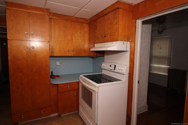 87 Hayden St, Windham, CT 06226 - kitchen featuring white range with electric stovetop, under cabinet range hood, brown cabinetry, light countertops, and a drop ceiling