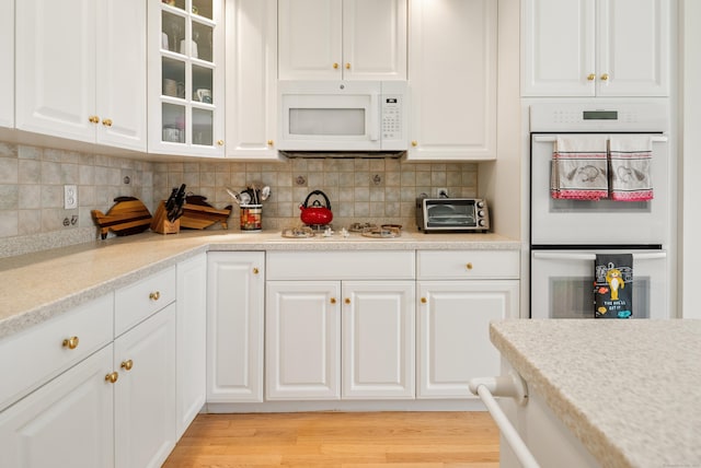 184 Stillson Rd Unit 184, Fairfield, CT 06825 - kitchen featuring white appliances, white cabinets, glass insert cabinets, and backsplash
