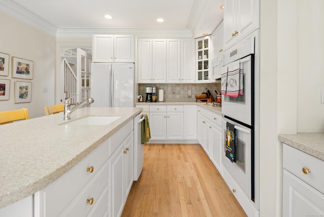 184 Stillson Rd Unit 184, Fairfield, CT 06825 - kitchen with white appliances, a sink, crown molding, light wood finished floors, and white cabinets