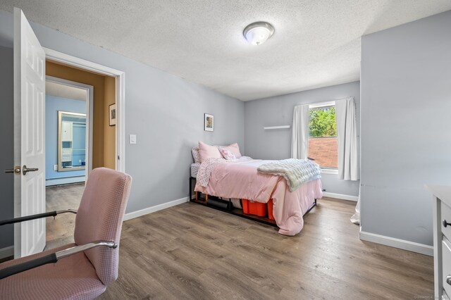 23 Lewis Rd, Preston, CT 06365 - bedroom with wood finished floors, a textured ceiling, baseboard heating, and baseboards