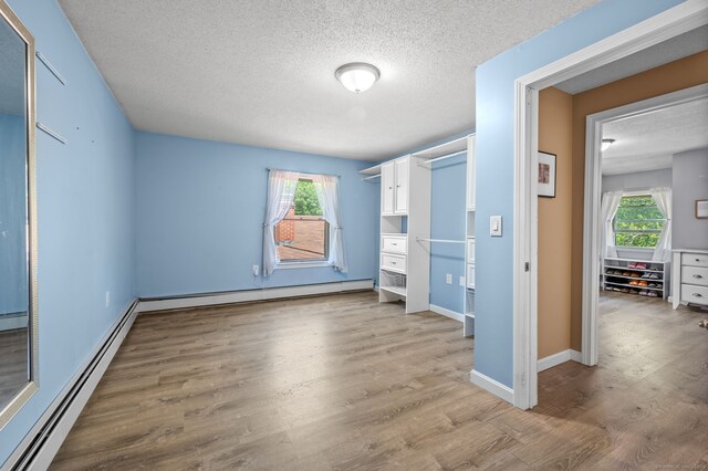 23 Lewis Rd, Preston, CT 06365 - unfurnished bedroom featuring a textured ceiling, baseboard heating, light wood-type flooring, and baseboards