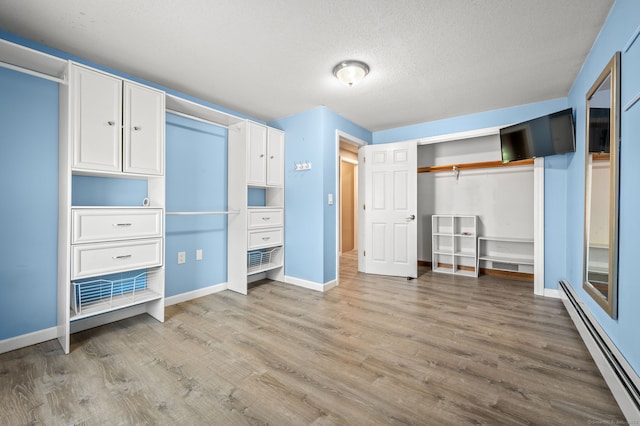 23 Lewis Rd, Preston, CT 06365 - unfurnished bedroom with a baseboard heating unit, light wood-type flooring, baseboards, and a textured ceiling