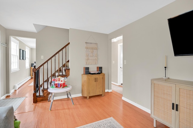 84 Wellman Rd, Manchester, CT 06040 - living room with a baseboard radiator, light wood-style flooring, and stairs