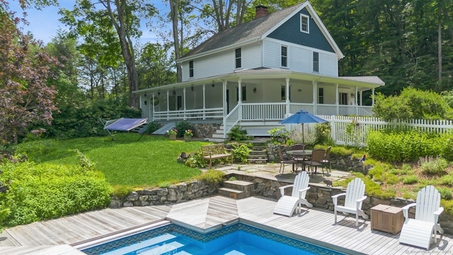 665 Lakeside Rd, Southbury, CT 06488 - back of house with a chimney, an outdoor pool, a wooden deck, and a shingled roof