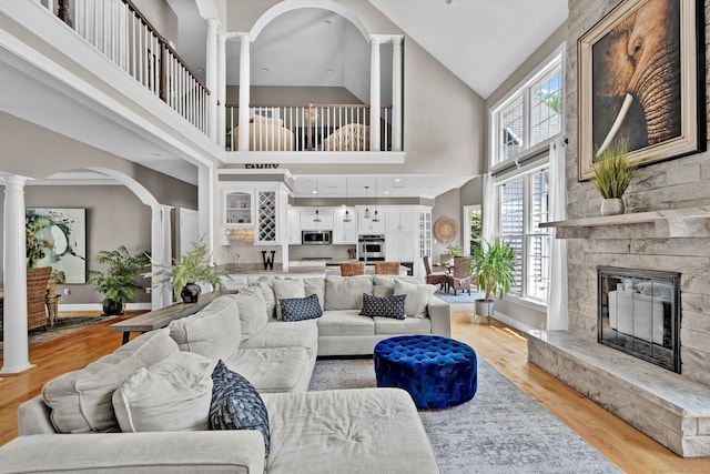 18 Cedar Spring Rd, Burlington, CT 06013 - living area featuring decorative columns, a fireplace, high vaulted ceiling, and light wood finished floors