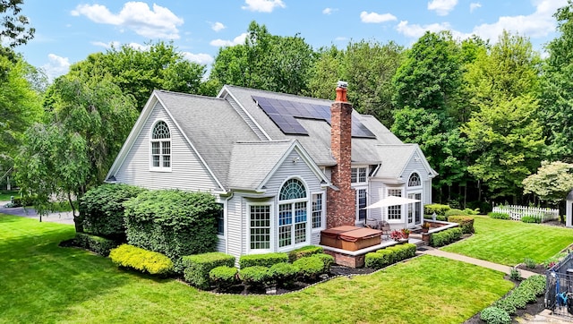 18 Cedar Spring Rd, Burlington, CT 06013 - back of house with a hot tub, solar panels, a shingled roof, and a chimney