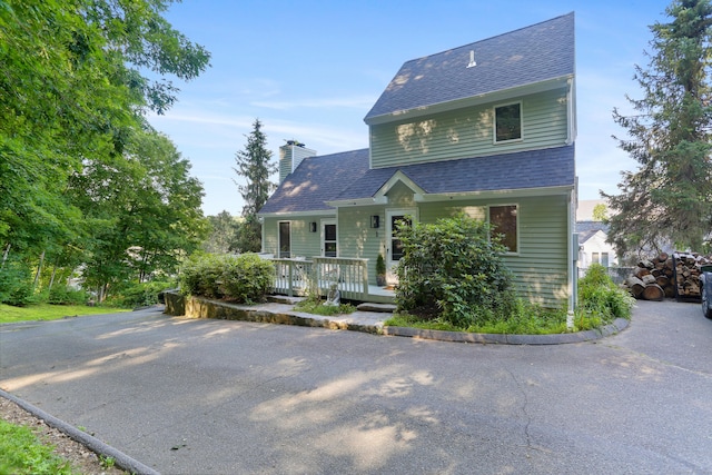 21 Hubbard Rd Apt 1, Wilton, CT 06897 - view of front of house with roof with shingles, a chimney, and covered porch