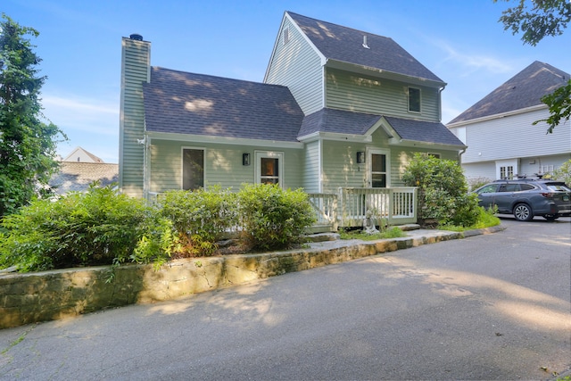 21 Hubbard Rd Apt 1, Wilton, CT 06897 - view of front facade with a chimney, covered porch, and roof with shingles