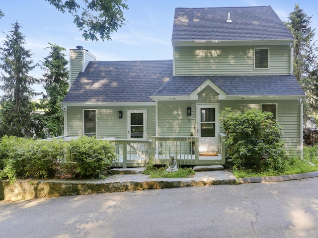 21 Hubbard Rd Apt 1, Wilton, CT 06897 - view of front of house featuring a chimney, roof with shingles, and a porch