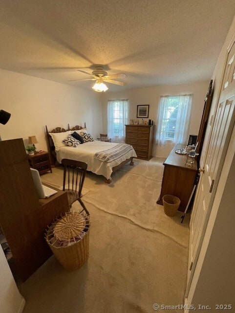 27 Shares Ln Unit 27, South Windsor, CT 06074 - bedroom with light colored carpet, a textured ceiling, and ceiling fan