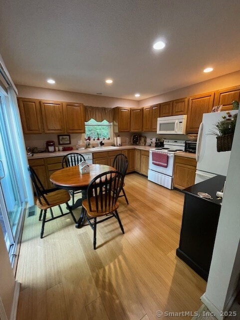27 Shares Ln Unit 27, South Windsor, CT 06074 - kitchen featuring white appliances, light wood-style floors, brown cabinets, recessed lighting, and light countertops