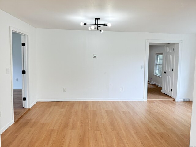 53 Cosey Beach Rd, East Haven, CT 06512 - spare room with a chandelier, light wood-style flooring, and baseboards