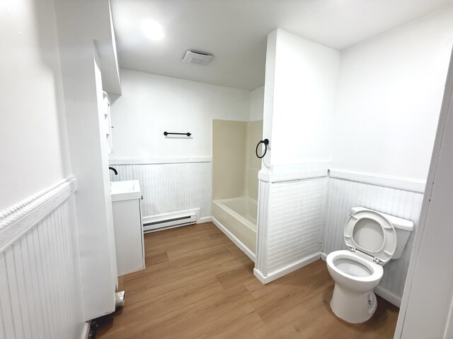 53 Cosey Beach Rd, East Haven, CT 06512 - bathroom with baseboard heating, wainscoting, toilet, vanity, and wood finished floors