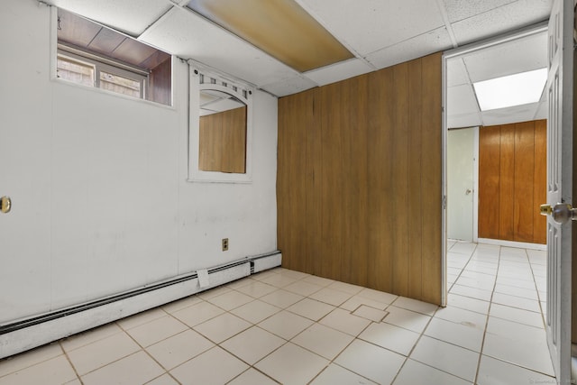 72 Maple St, Norwalk, CT 06850 - basement featuring a baseboard radiator, wooden walls, a paneled ceiling, and light tile patterned floors